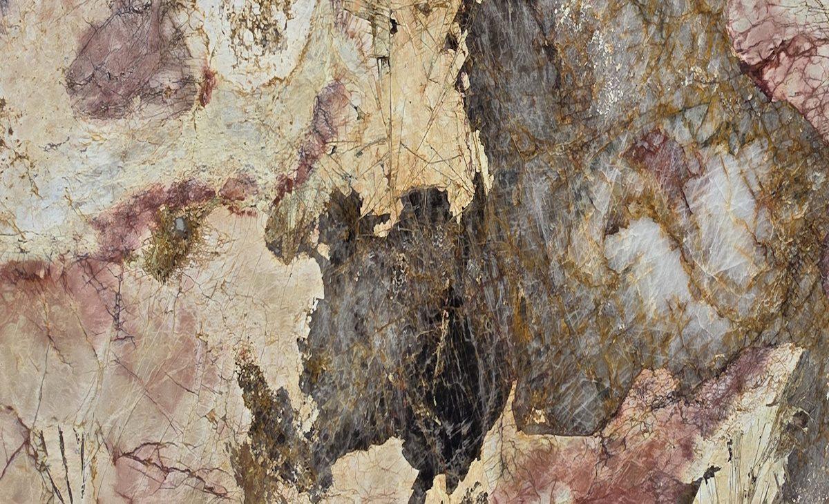 Exotic granite slab with cream, burgundy, smoky gray and black areas and gold veining