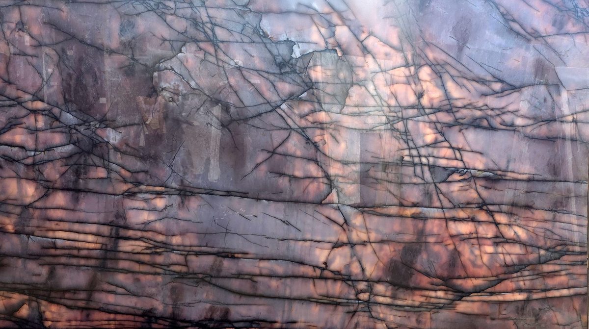 Backlit translucent stone slab glowing pink and purple with dark branching veins